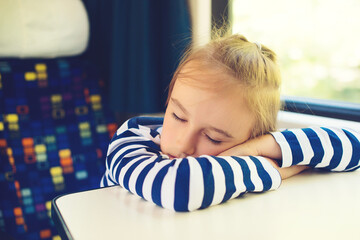 Little child sleeping in a train. Travel, traveling with small children. Cute boy is traveling on the train.