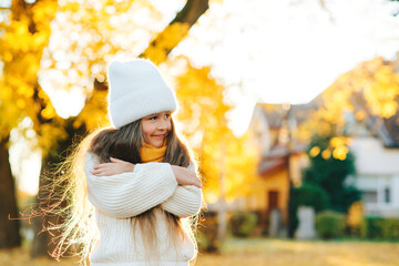 Cute child smiling and posing outdoors. Little girl wearing warm knitted sweater. Autumn kids fashion, lifestyle.