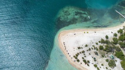 Aerial view of a white sand cay surrounded by a coral reef