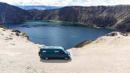 View of a campervan on the edge of a crater filled with water
