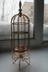 Gold metal candle holder in the shape of a bird cage. Interior detail - 743938598
