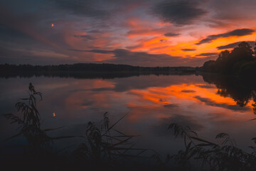 beautiful colorful sunset over the lake with reflection in a landscape park in Poland