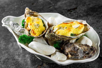 Baked oyster with hollandaise sauce, brie cheese and spinach