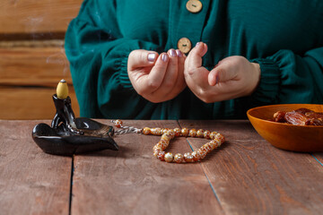 A Muslim woman's hand in prayer at the table before the start of the Ramadan fast