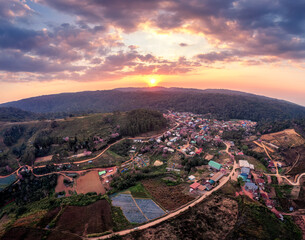 Sunset over Thai tribe village with wild himalayan cherry tree blooming in countryside at Ban Rong Kla