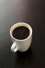 White cup of coffee on wooden table