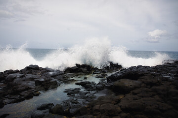 Fototapeta na wymiar black coastline with waves on Kauai, Hawaii