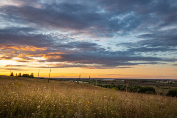 Evening rural landscape with a warm sunset and endless open spaces, view of the countryside from a...