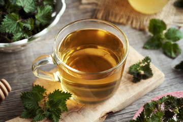 A cup of herbal tea with fresh nettles collected in spring