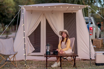 Woman sitting in front of camping tent during vacation