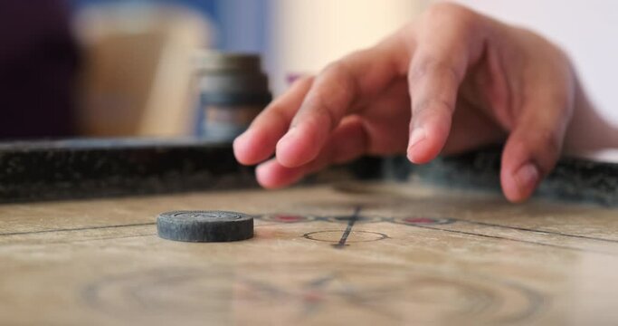 Close Up of Player Striking a Carrom Board with a Striker