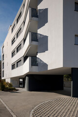 Modern condominium painted white with very particular protruding balconies. Residential neighborhood in Switzerland.