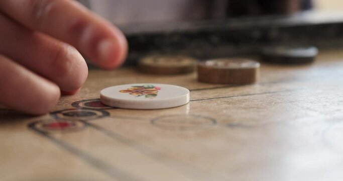 Close Up of Hand Striking White Carrom Striker on Board, Traditional Indoor Game and Recreational Sports
