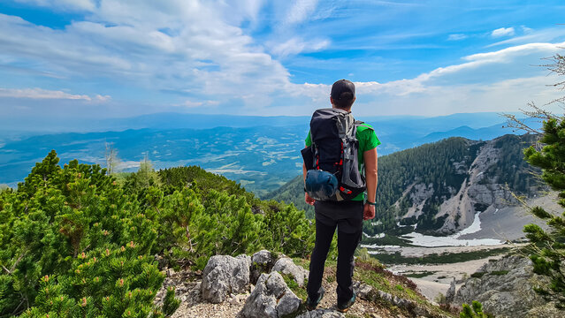 Hiker man looking at alpine valley on way to mountain peaks Feistritzer Spitze (Hochpetzen), Karawanks, Carinthia, Austria. Wanderlust Austrian Alps. Hiking trail on Petzen, Bleiburg, V&ouml;lkermarkt
