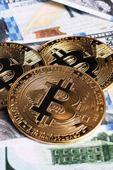 Fototapeta na wymiar Three bitcoins on a dollar bills closeup