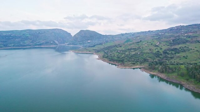 Aerial view drone of daylight. Flying over blue water. Lake surrounded by mountains	and trees
