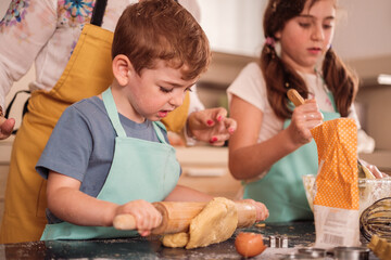 Mother cooking some cookies with her children to share moments in their development. motherhood