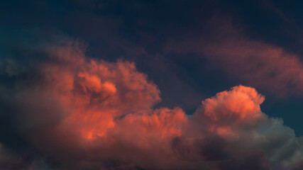 Vivid sunset clouds, a mix of dark and illuminated, creating a dramatic sky.