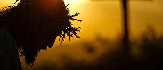 Silhouette of Jesus Christ head bowed, wearing the crown of thorns. Blurred background. Easter and other christian holidays background with copy space. 