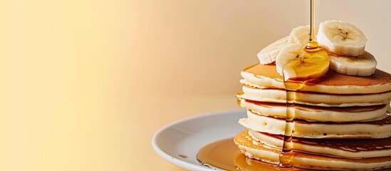 pancakes with banana and syrup on white plate. with copy space image. Place for adding text or design