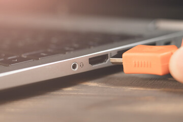 Man is insert the cable HDMI into the Port for information transfer. Close up, modern technology. Side panel on a laptop. Different ports for connection.