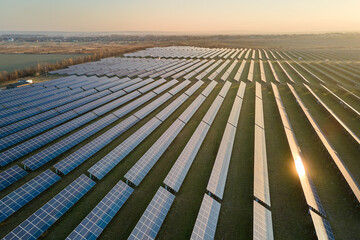 Aerial view of large sustainable electrical power plant with rows of solar photovoltaic panels for...