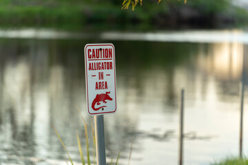Alligator warning sign in Florida park about caution and safety during walking near water
