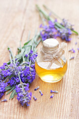 Obraz na płótnie Canvas Lavender oil or extract on wooden background with fresh flowers nearby, copy space, natural medicine, herbal remedy for insomnia and stress, natural hair and skin treatment, aromatherapy concept