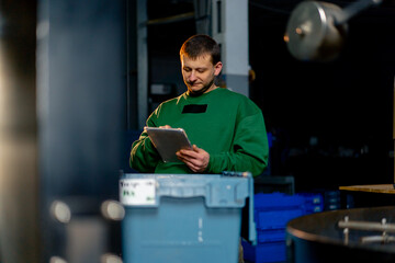 At a coffee roasting factory worker checks the quality of the finished coffee