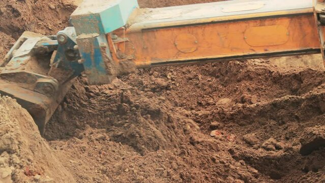 A modern excavator with a rotary bucket and a telescopic boom digs a hole, transfers soil. Industry
