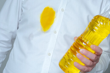 A dirty yellow grease stain of oil or sauce on a white shirt. Spoiled clothes. daily life stain...