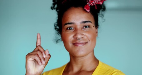 Young African American woman having eureka moment, close-up of one black latina adult girl having an epiphany idea pointing finger up feeling joy and HOPE