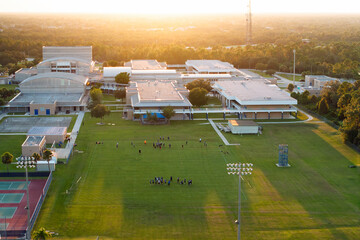 Public school sports arena in North Port, Florida with school kids playing American football on...