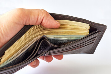 man's hand counting American dollars in wallet
