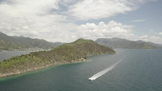 Aerial footage of a speed boat navigating through a sound on a sunny day