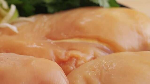 Raw chicken meat on plate close-up. Preparing raw food for cooking. Grilled chicken, duck, turkey kebab with vegetables.