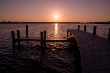 Obraz premium The rising sun centered above a dock on the St. Johns River in Florida