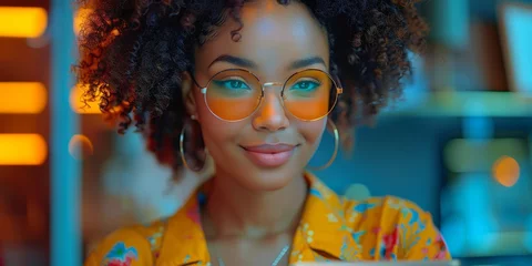 Fotobehang A youthful woman with a bright smile and a stylish jheri curl sits indoors, her glasses adding a touch of sophistication to her yellow shirt and adding to the warm and inviting atmosphere of the port © Larisa AI