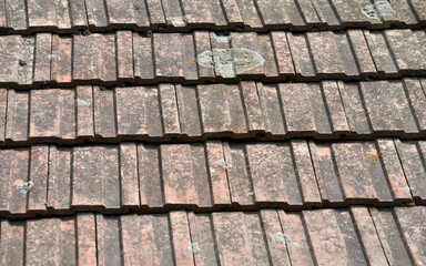 On the roof of the house is an old red tile