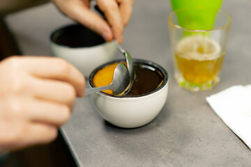 close-up at coffee roasting factory in the kitchen, a bowl of coffee is collected with spoons of foam