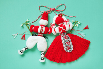 Red and white symbol of the holiday March 1 Martenitsa, figures of a boy and a girl with bouquets of snowdrop flowers on a green background. Postcard for Martisor, Baba Marta - obrazy, fototapety, plakaty