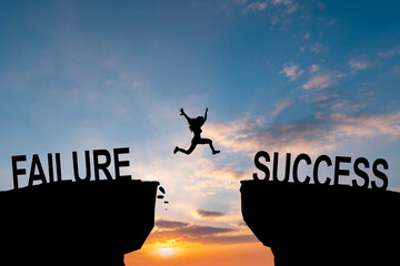 Man jump across text failure to success over cliff on sunset background concept for being...