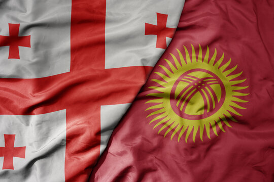 big waving national colorful flag of kyrgyzstan and national flag of georgia .