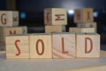 Wooden alphabet blocks isolated on white with sentence "SOLD"