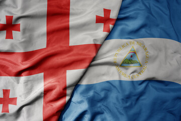 big waving national colorful flag of nicaragua and national flag of georgia .