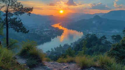  the sun is setting over the mountains and a river in the middle of a valley with trees in the foreground and a small town on the other side of the river.
