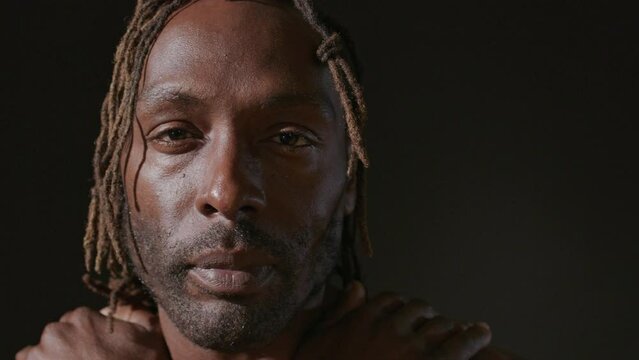 Tight shot of a man with dreadlocks on a black backdrop