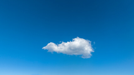 A single cloud in the blue sky.