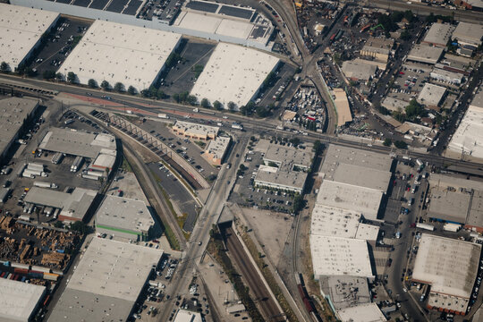 An aerial photo of the Alameda Corridor, an expressway for trains moving through Vernon, Los Angeles, and other areas in the broader LA area. The train track runs through a trench without car traffic.