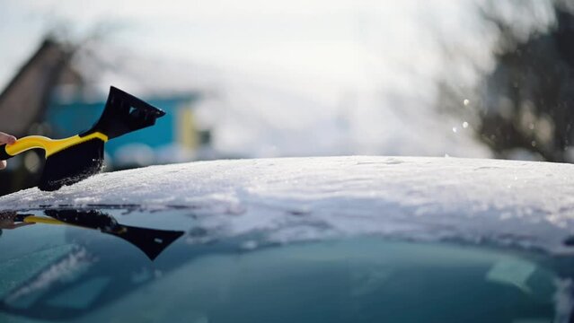Woman Driver Cleaning Car from Snow with a Brusher Scraper	